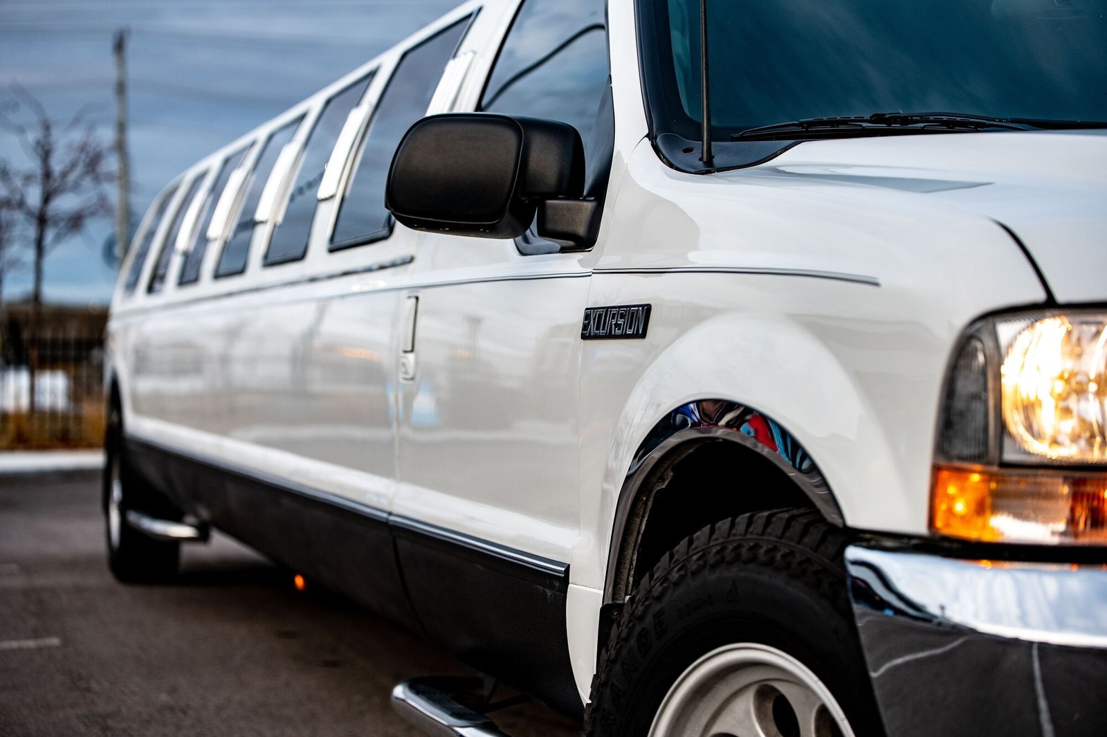 A white stretch limousine parked at dusk, ready for chauffeured limousine service across Miami.